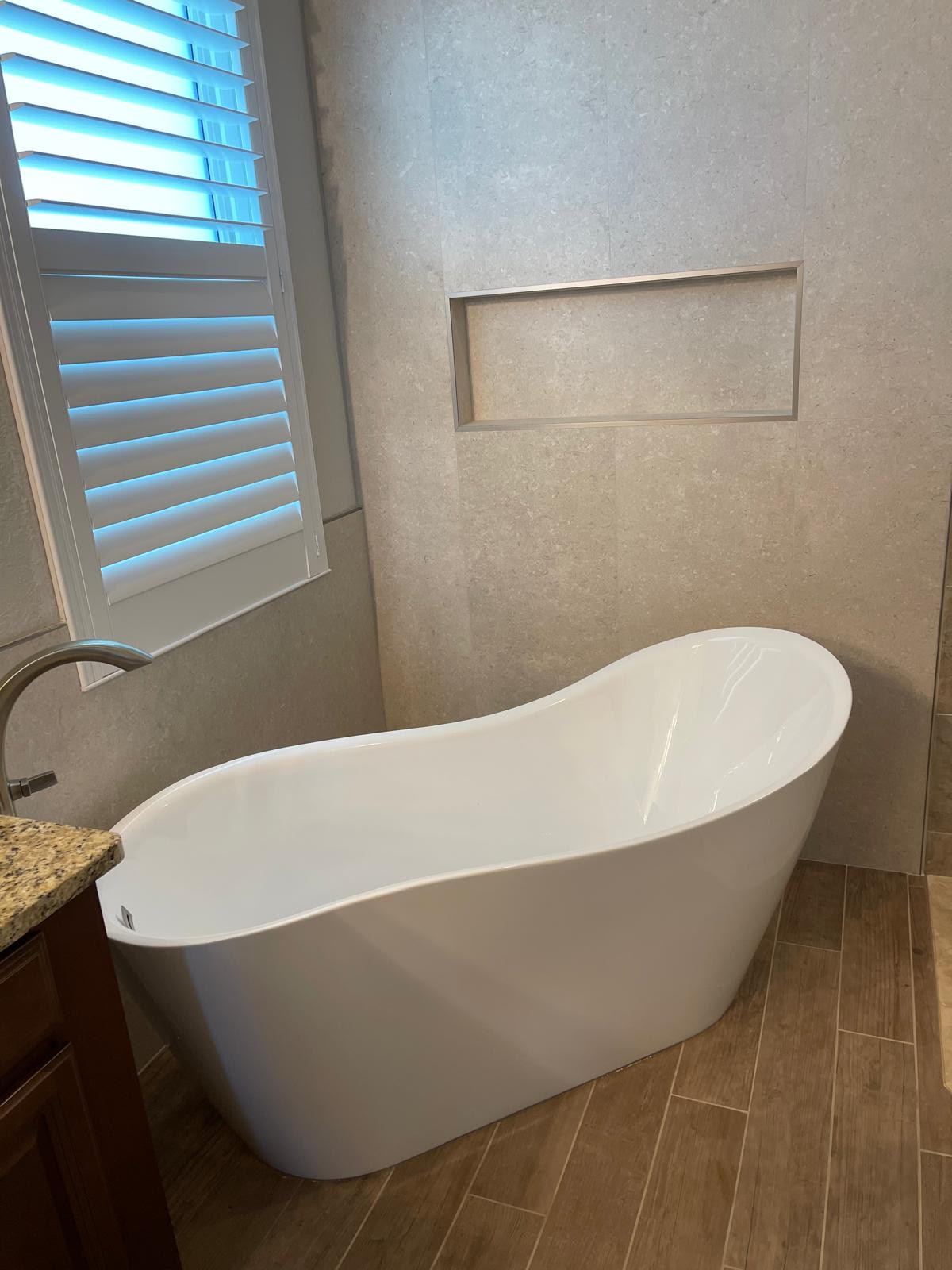 Bathroom remodel with freestanding tub and tile wall niche