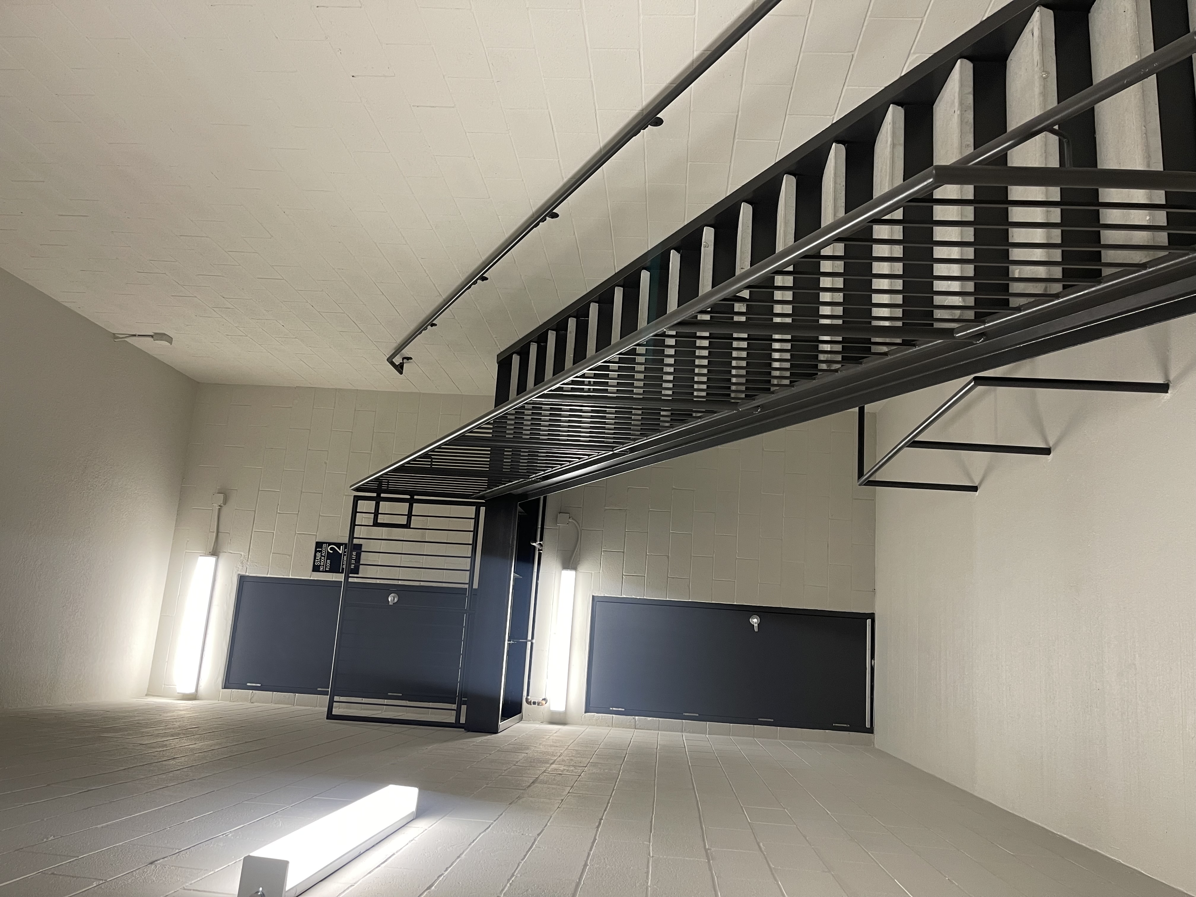 Commercial stairwell painting with black metal handrail finish