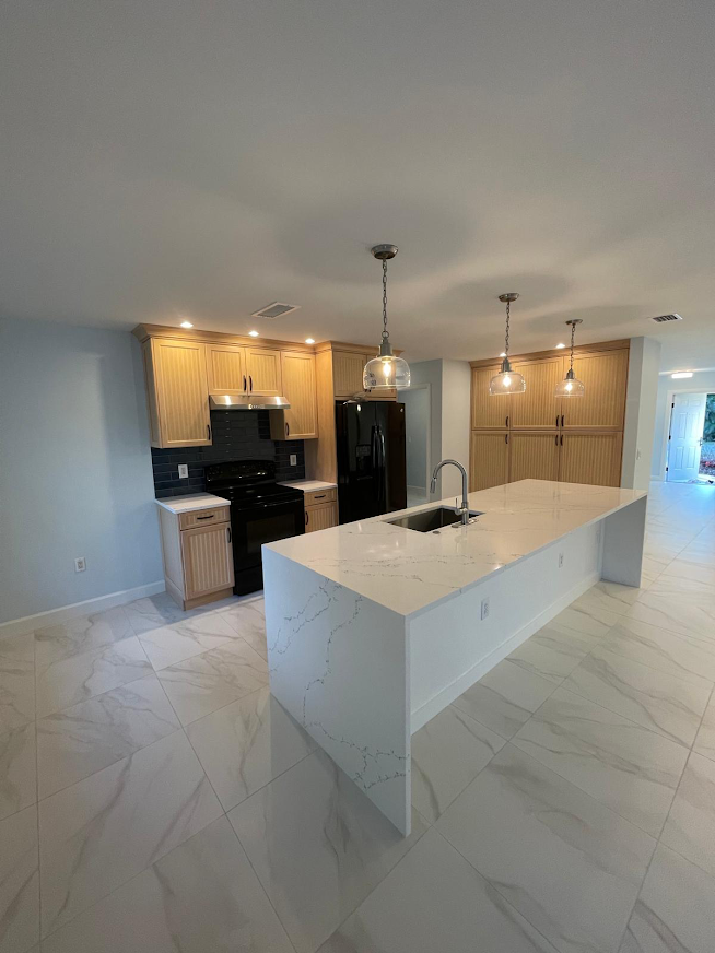 Finished kitchen remodel with large island and light wood cabinets